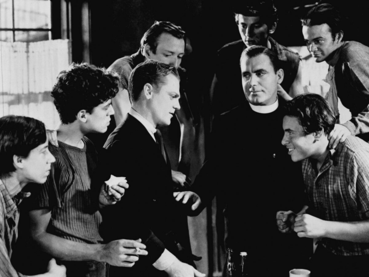 Rocky Sullivan (James Cagney, L) and Father Jerry Connelly (Pat O'Brien) surrounded by street kids (Dead End Boys), in "Angels With Dirty Faces." (Warner Bros)