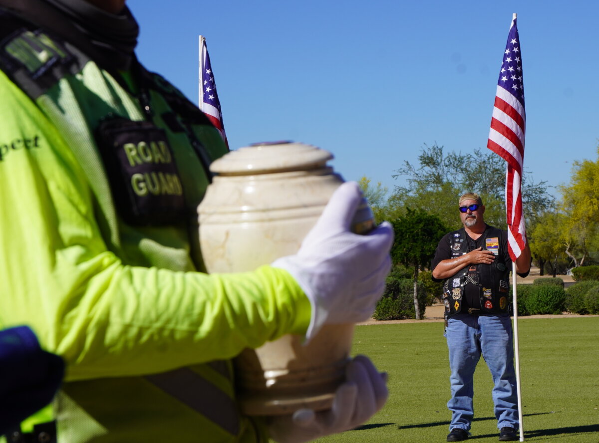 A volunteer carries the cremation urn during a funeral service for 14 veterans and a spouse at the National Memorial Cemetery in Phoenix, Ariz., on March 18, 2026. Every other month, the nonprofit Missing In America Project sponsors the veteran interments. (Allan Stein/The Epoch Times)