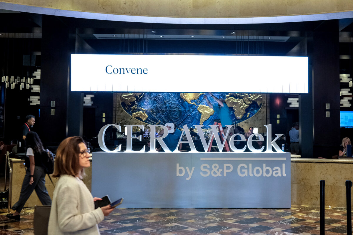 A woman walks past a sign of CERAWeek in Houston on March 22, 2026. (Ronaldo Schemidt/AFP via Getty Images)