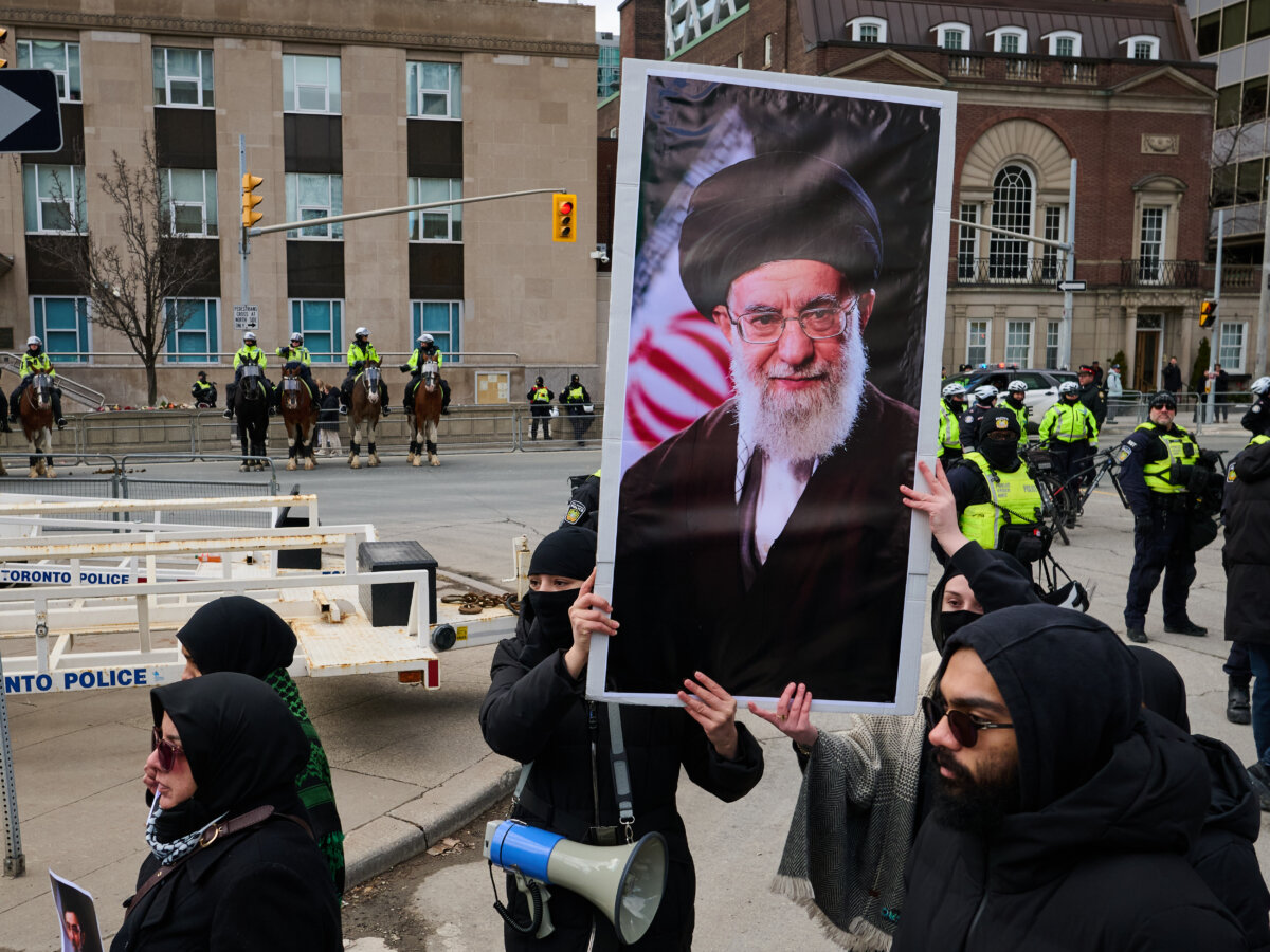 Protesters hold a portrait of Iran's former Supreme Leader Ayatollah Ali Khamenei as they demonstrate by the U.S. Consulate during a rally for Al-Quds Day in Toronto, on March 14, 2026. (Sammy Kogan/The Canadian Press)