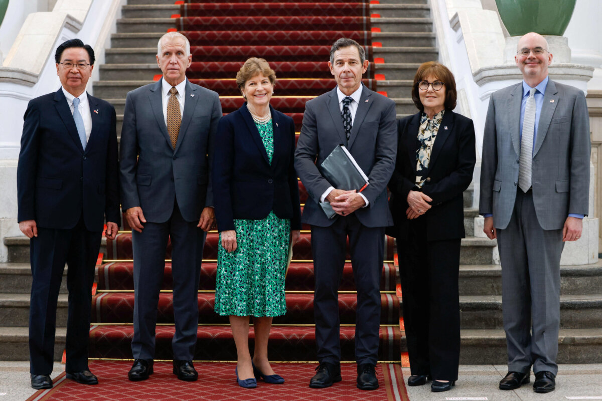 (L–R) Taiwanese National Security Council Secretary-General Joseph Wu and U.S. Sens. Thom Tillis (R-N.C.), Jeanne Shaheen (D-N.H.), John Curtis (R-Utah), and Jacky Rosen (D-Nev.) pose with Director of the American Institute in Taiwan Raymond Greene as they attend a press conference at the Presidential Office Building in Taipei, Taiwan, on March 30, 2026. (Ann Wang/Reuters)