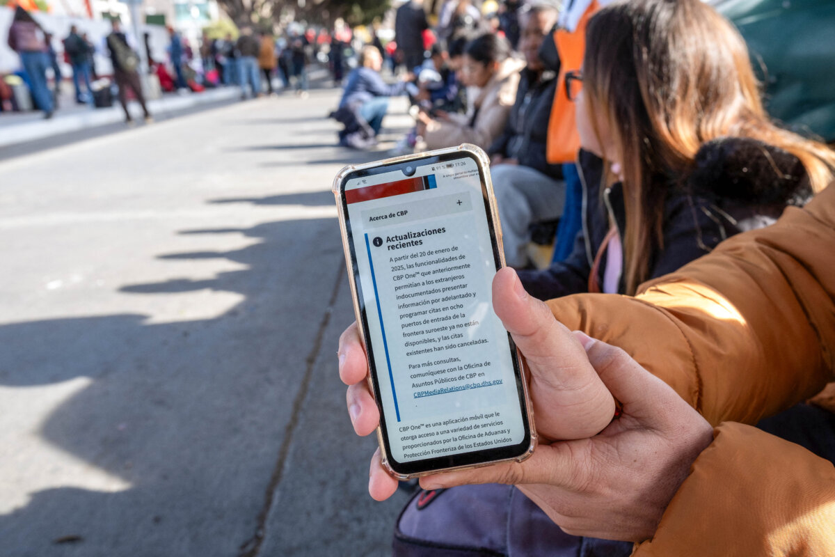 An asylum seeker shows an updated message on the CBP One app mentioning that all appointments have been cancelled as they wait for their CBP One appointment with US Authorities before crossing through El Chaparral port in Tijuana, Baja California state, Mexico, on Jan. 20, 2025. (Photo by Guillermo Arias /AFP via Getty Images)