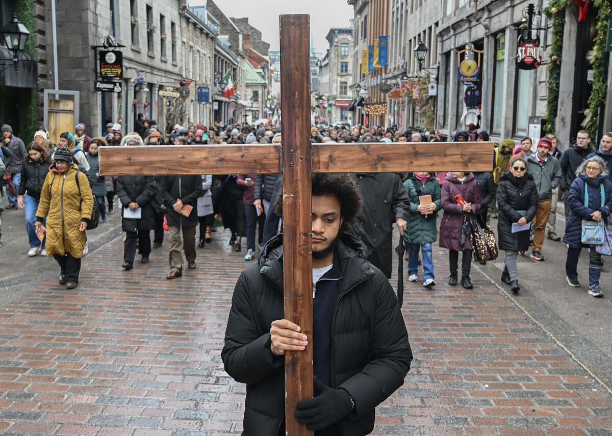 A man carries a cross during a Way of the Cross procession in Montreal, on April 3, 2026. (The Canadian Press/Graham Hughes)