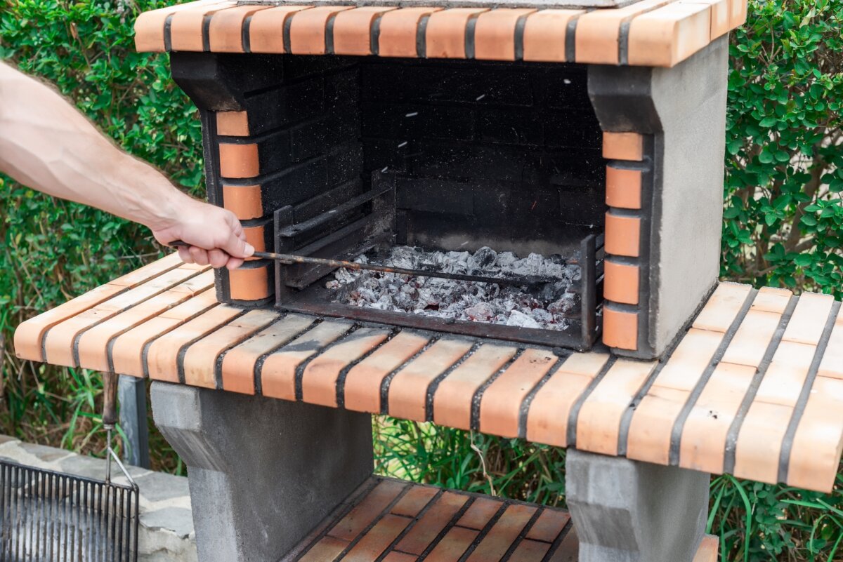 Designing and building a grill that uses charcoal, as opposed to gas, is a good choice that's easy to build and cooks more flavorful foods. (Fran Rodriguez Fotografia/Shutterstock)