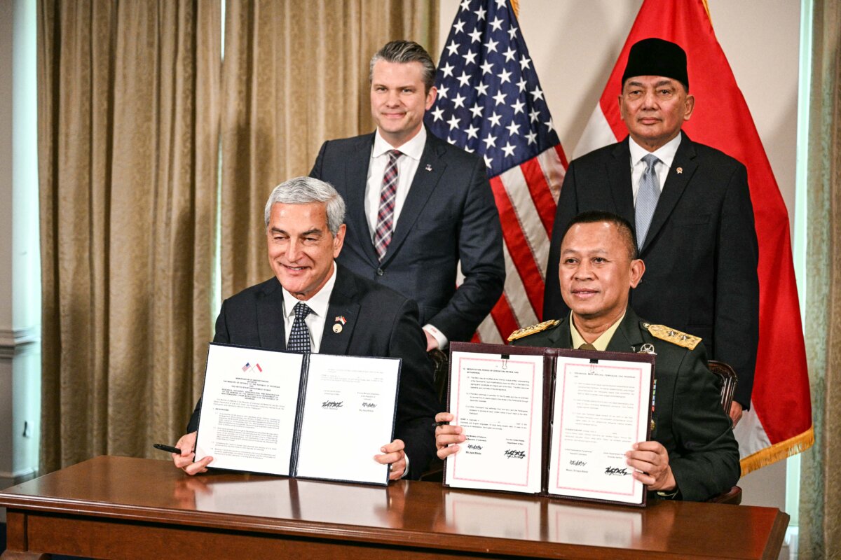U.S. Secretary of War Secretary Pete Hegseth (Top-L) and Indonesian Defense Minister Sjafrie Sjamsoeddin (Top-R) pose for a photo with U.S. Air Force Maj. Gen. Kelly McKeague (L) and Indonesian Maj. Gen. Agus Widodo (R) as they hold a signed memorandum of understanding at the Pentagon in Washington on April 13, 2026. Emphasizing that both countries share a "peace through strength" approach, Hegseth said that the U.S. and Indonesia are increasing military cooperation. (Jim Watson/AFP via Getty Images)