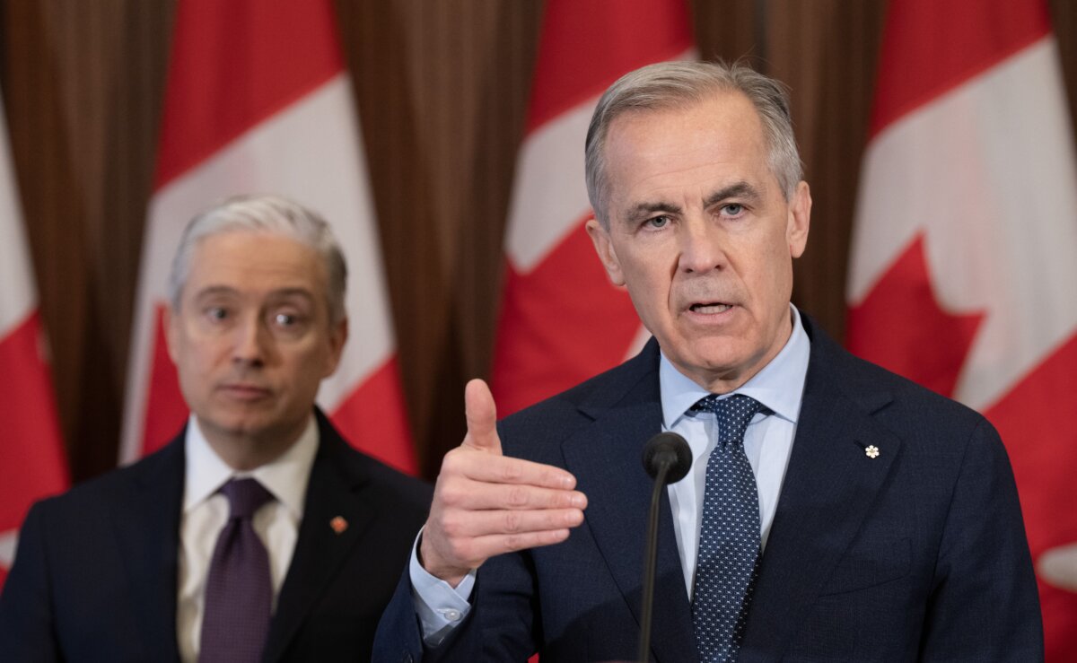 Finance and National Revenue Minister Francois-Philippe Champagne looks on as Prime Minister Mark Carney responds to a question during an announcement on Parliament Hill in Ottawa on April 14, 2026. (The Canadian Press/Adrian Wyld)