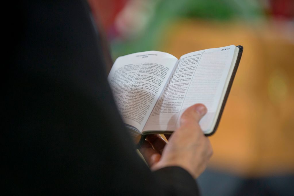 A man reads scripture while viewing the casket of Reverend Billy Graham in the U.S. Capitol Rotunda in Washington, DC, on Feb. 28, 2018. (Alex Edelman/AFP via Getty Images)