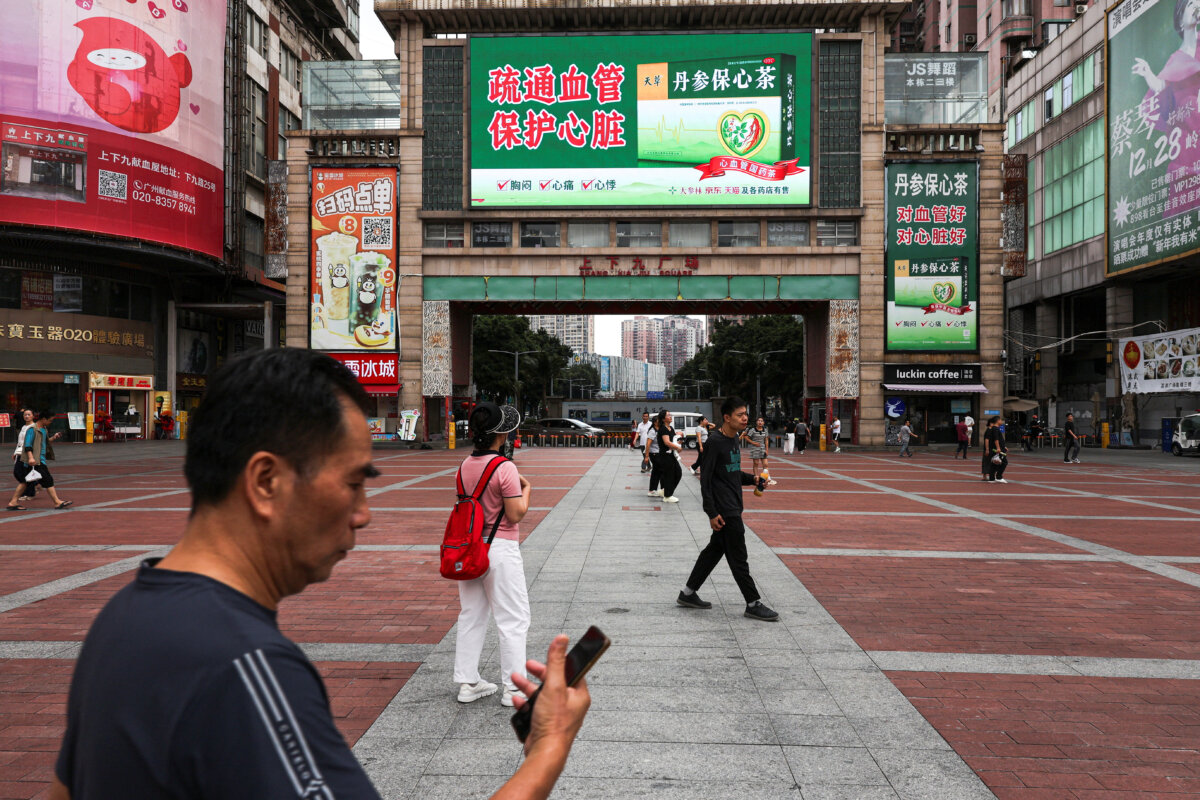 People walk in a square in Guangzhou, Guangdong Province, China, on April 15, 2026. (Go Nakamura/Reuters)