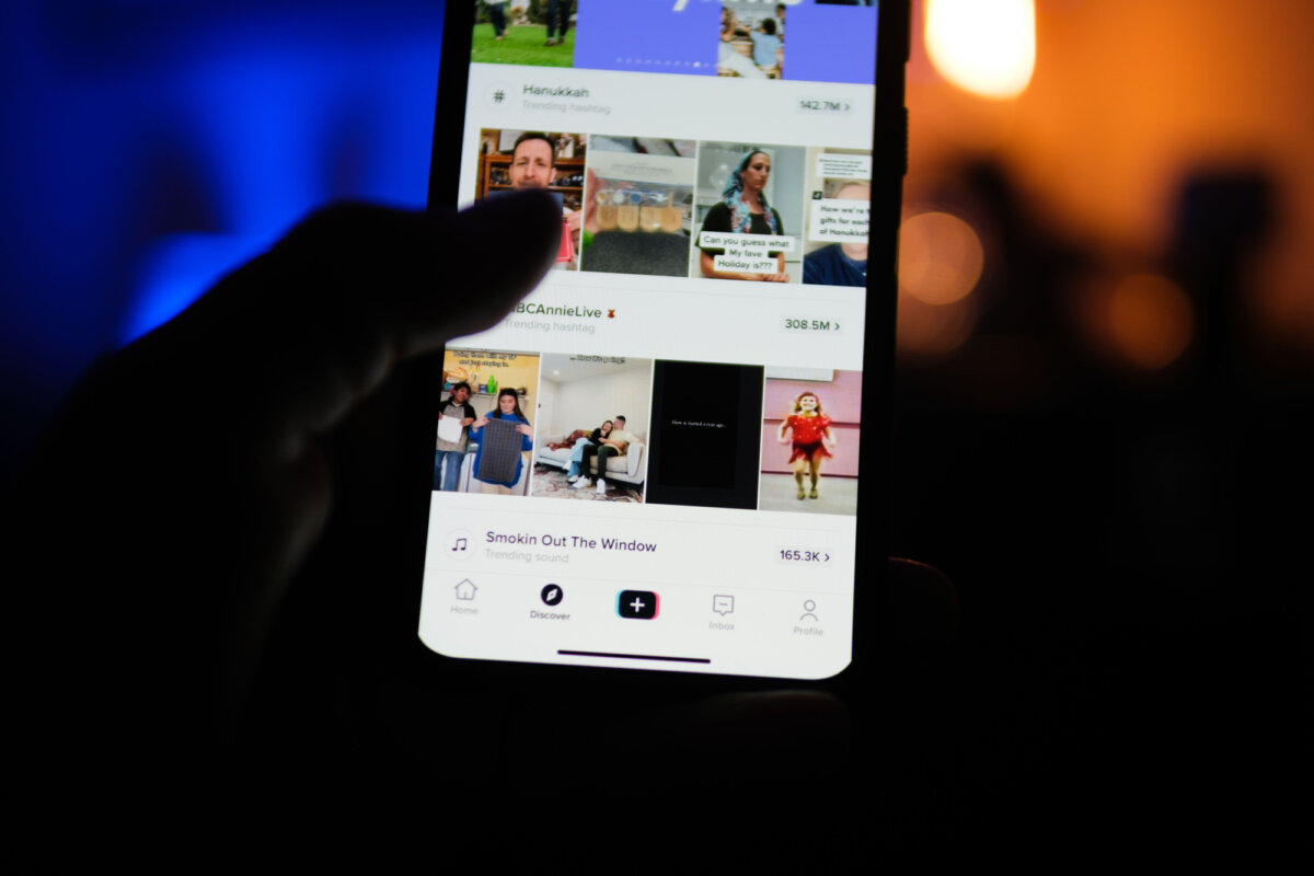 A man holds a phone displaying the TikTok app in this file photo. (Oleksii Pydsosonnii/The Epoch Times)