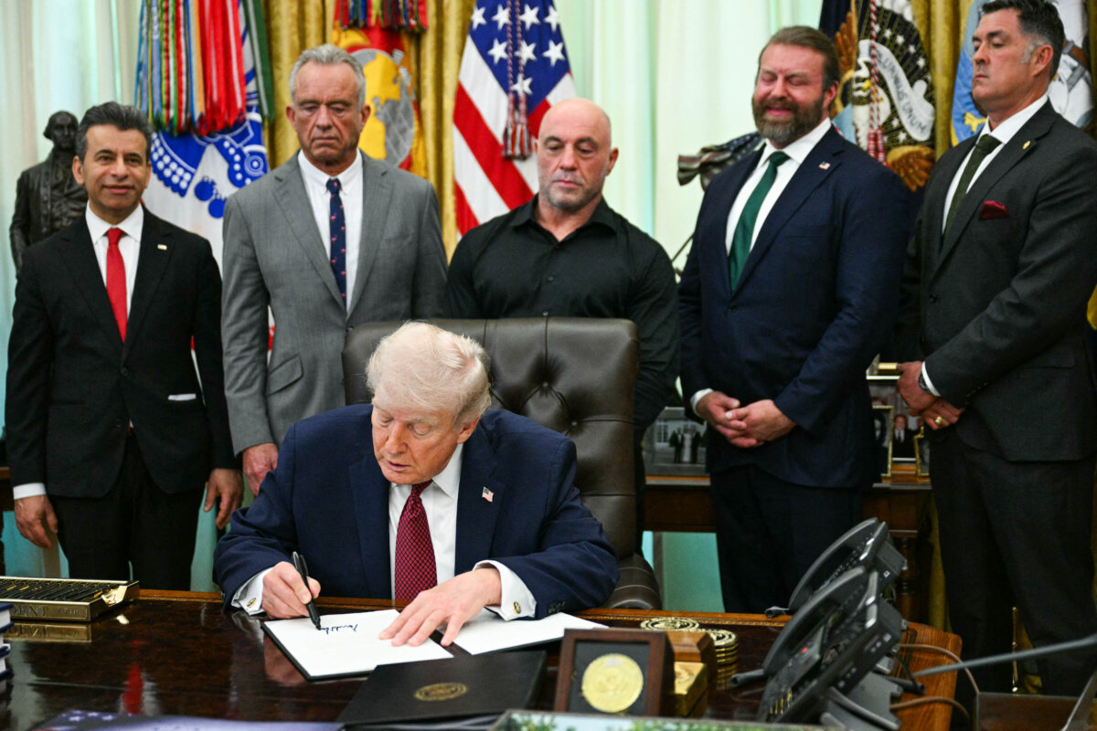 (L-R) FDA Commissioner Marty Makary, Health and Human Services Secretary Robert F. Kennedy Jr., US media personality Joe Rogan, W. Bryan Hubbard, CEO of Americans for Ibogaine, and former Navy SEAL Marcus Luttrell look on as U.S. President Donald Trump signs an executive order in the Oval Office on April 18, 2026. The executive order aims to further U.S. federal medical research and clinical trials for certain psychedelic drugs. (Jim WATSON / AFP via Getty Images)