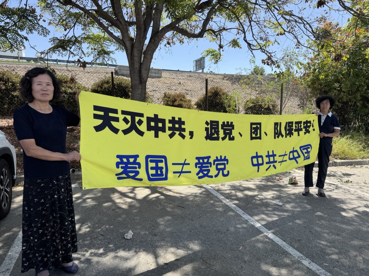 May Zhang (L) holds a banner with another Falun Gong practitioner in the City of Industry, Calif., on April 19, 2026. The banner reads: “Heaven Eliminates the CCP,” “Quit the CCP,” “Love China ≠ Love the CCP,” and “The CCP ≠ China.” (The Epoch Times)