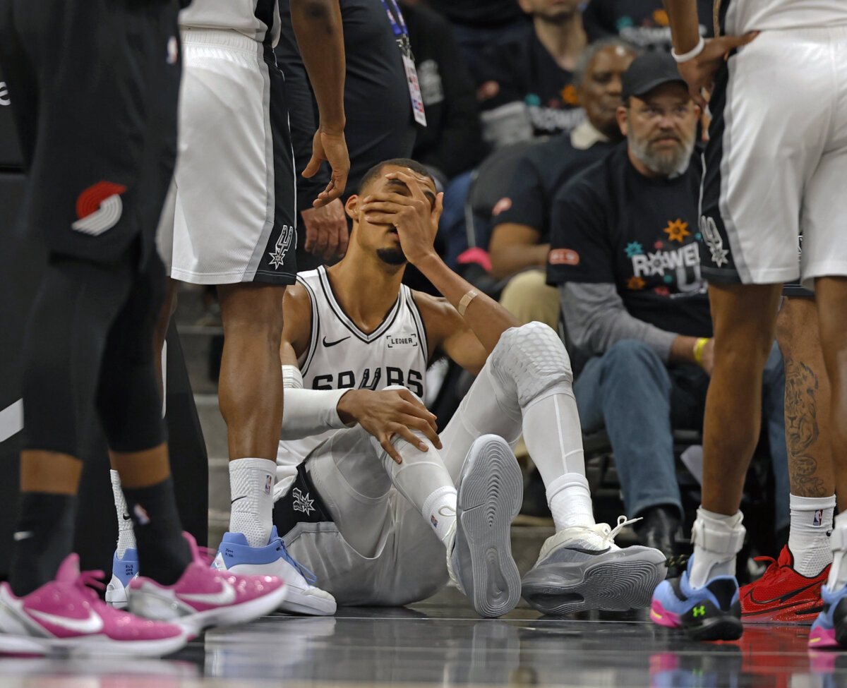 Victor Wembanyama of the Spurs holds his head after falling to the court against the Portland Trailblazers in the first half of Game Two of the Western Conference First Round NBA Playoffs at Frost Bank Center in San Antonio on April 21, 2026. (Ronald Cortes/Getty Images)