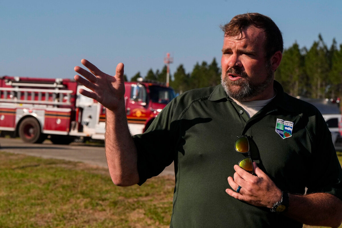 Seth Hawkins of the Georgia Forestry Commission speaks to reporters as fire crews and trucks assemble at the Brantley County Airport near the Brantley Highway 82 fire, near Nahunta, Ga., on April 23, 2026. (Mike Stewart/AP Photo)