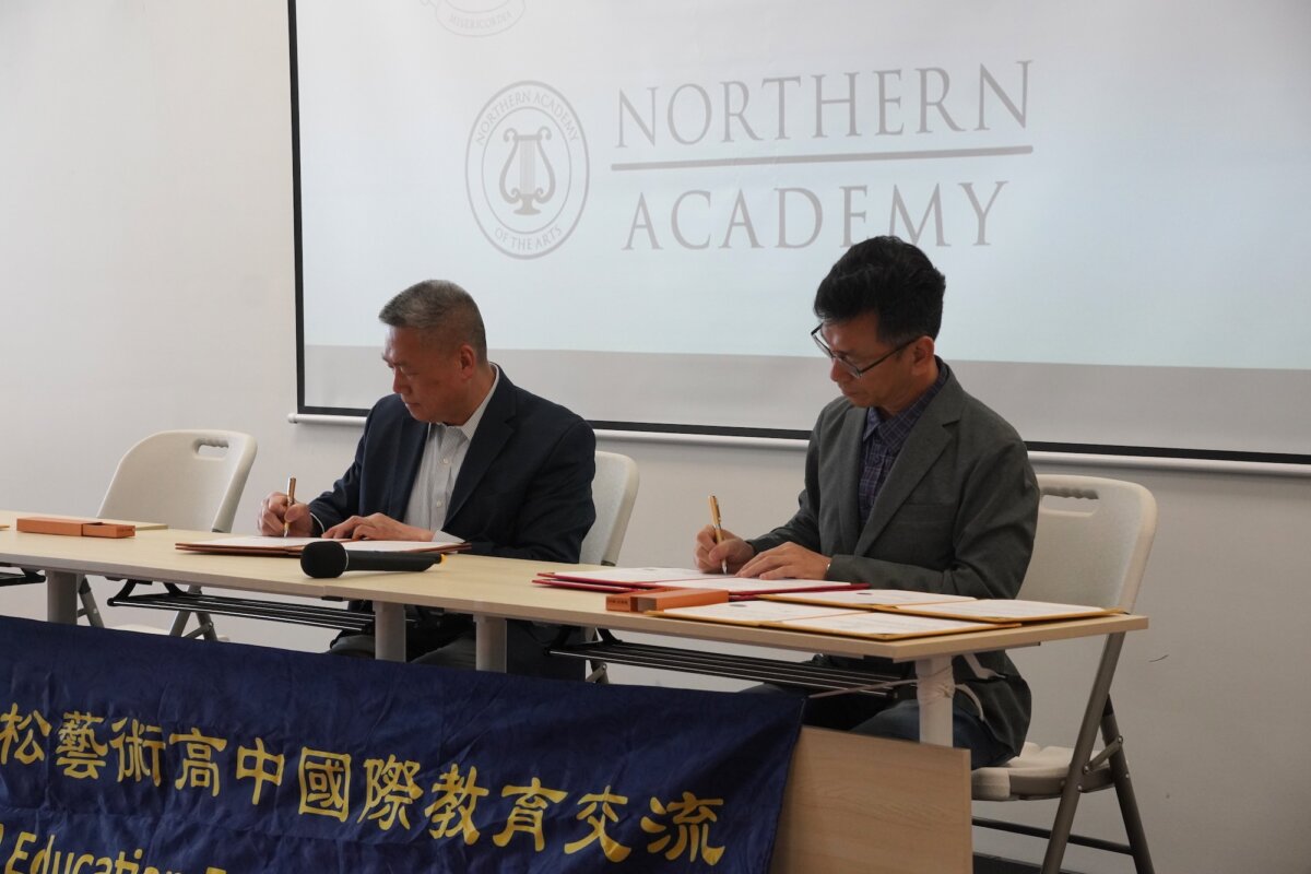 Fei Tian College Northern Vice President Joseph Zhao (L) and Niaosong High School of the Arts Principal Benjamin Wu sign memorandums of understanding at Fei Tian College Northern in Middletown, N.Y., on April 22, 2026. (Oliver Mantyk/The Epoch Times)