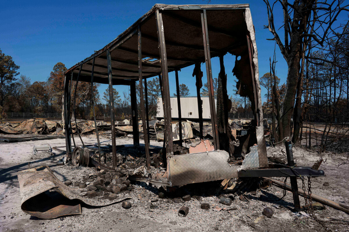 A burned trailer sits near a destroyed home as the Brantley Highway 82 fire burns near Nahunta, Ga, on April 23, 2026. (AP Photo/Mike Stewart)