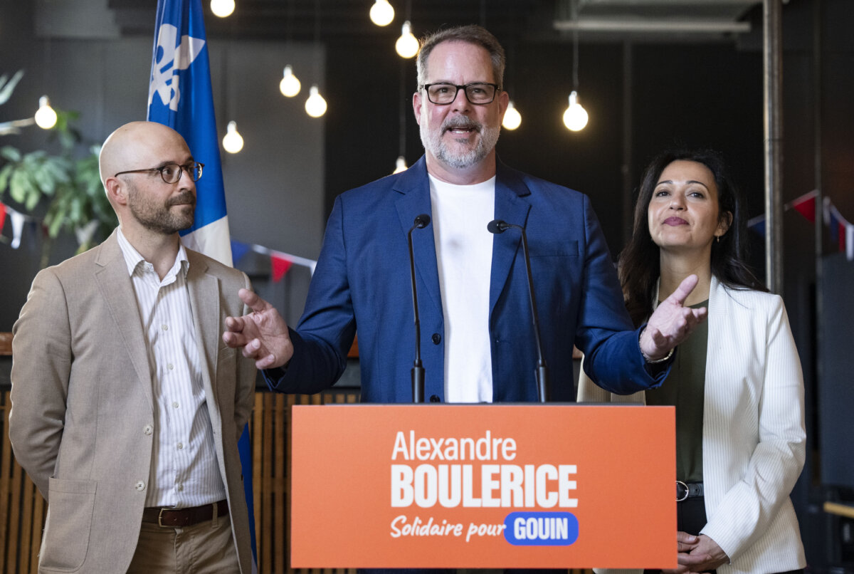 Alexandre Boulerice, centre, federal MP for the riding of Rosemont-La Petite-Patrie, flanked by Quebec Solitaire co-spokesperson Ruba Ghazal, right, and Sol Zanetti announces his intention to leave federal politics and the NDP party and run provincially with Quebec Solidaire, in Montreal on April 27, 2026. (The Canadian Press/Christinne Muschi)