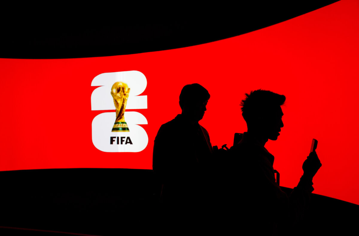 People are silhouetted against a video screen during the launch of the FIFA World Cup trophy tour in Vancouver, Canada, on April 10, 2026. (The Canadian Press/Darryl Dyck)