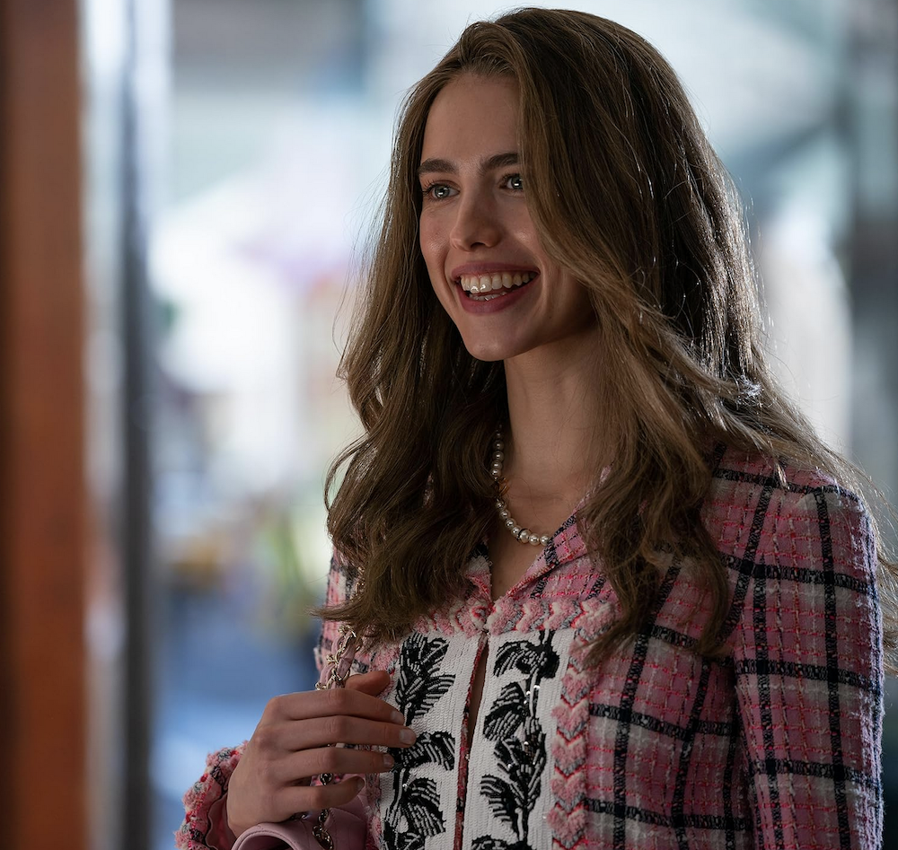 woman in pink plaid jacket in How to Make a Killing