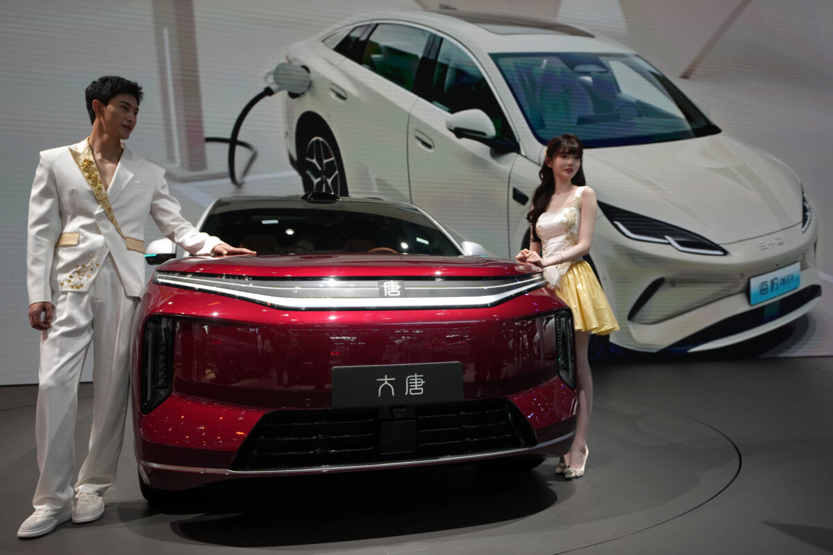 Models stand next to a latest EV car from Chinese automaker BYD showcased at the Auto China 2026 in Beijing on April 25, 2026. (Andy Wong/AP Photo)