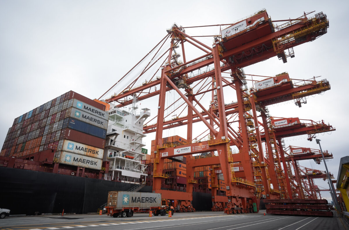 A transport truck carries a cargo container to be loaded on the Hapag-Lloyd container ship Frankfurt Express at the DP World Centerm terminal at port, in Vancouver, on Aug. 3, 2025. (The Canadian Press/Darryl Dyck)