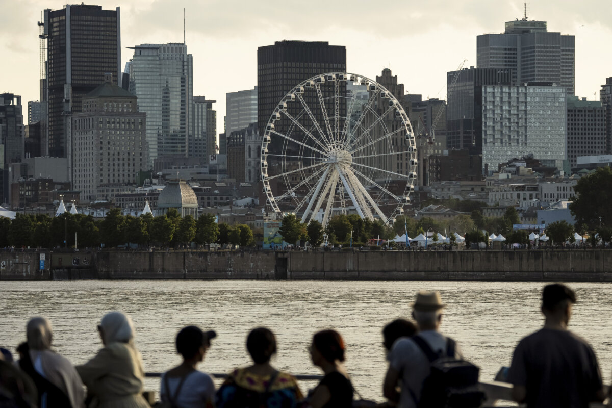 People watch the Montreal skyline on Aug. 14, 2025. (The Canadian Press/Christopher Katsarov)