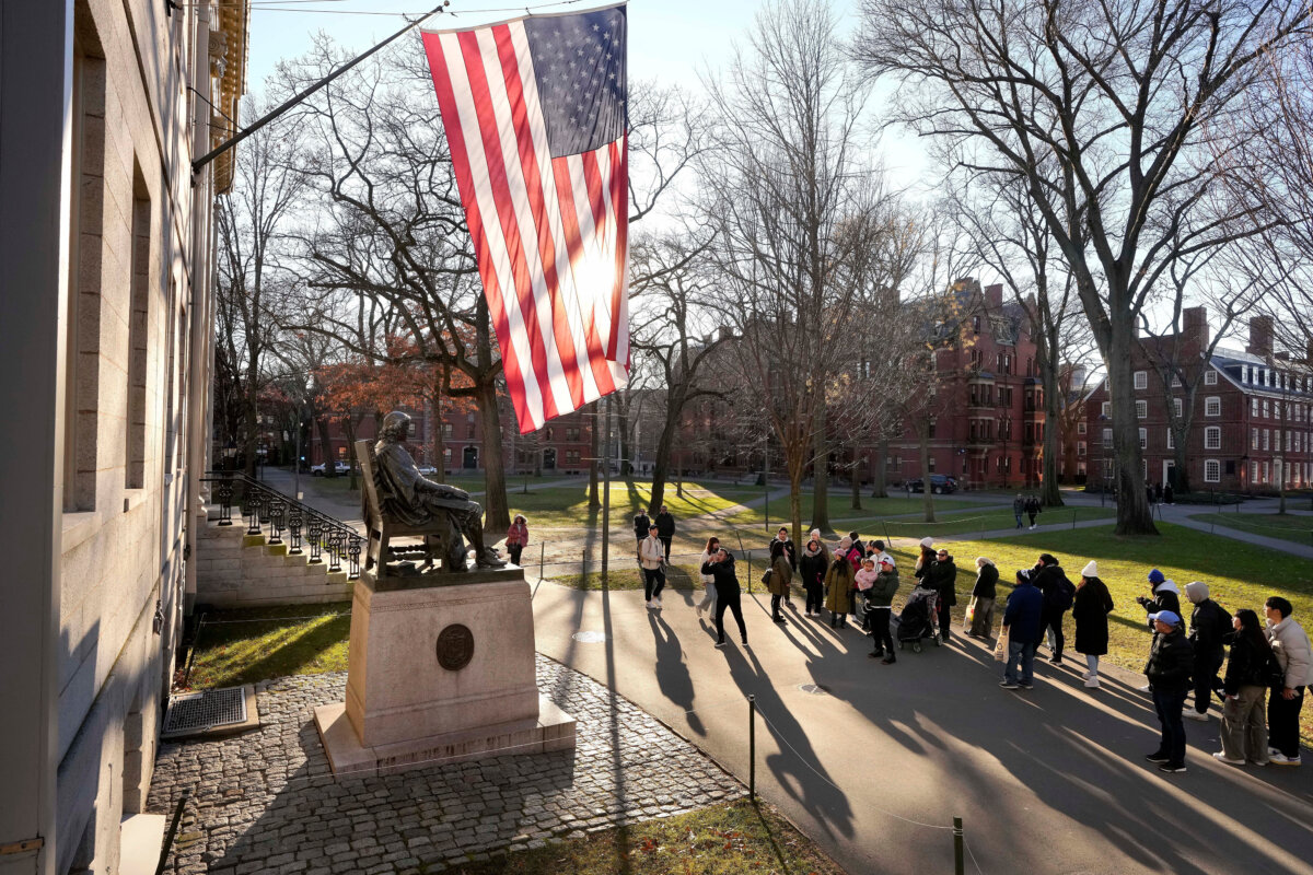 People take photos near a John Harvard statue (L) on the Harvard University campus in Cambridge, Mass., on Jan. 2, 2024. (Steven Senne/AP Photo)