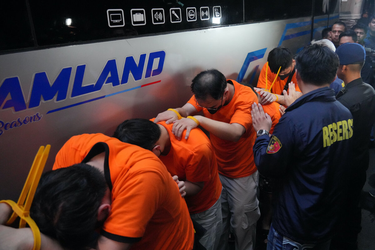 Indonesian police officers escort foreign nationals in a raid on an alleged online gambling operation, in Jakarta, Indonesia, on May 10, 2026. (Achmad Ibrahim/AP Photo)
