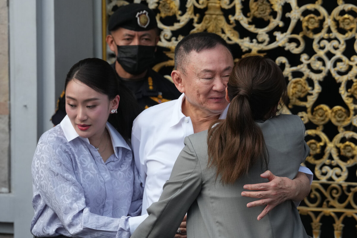 Former Thailand Prime Minister Thaksin Shinawatra (C) hugs his daughters, former Prime Minister Paetongtarn (L), and Pinthongta, after he was released on parole from prison in Bangkok on May 11, 2026. (Sakchai Lalit/AP Photo)