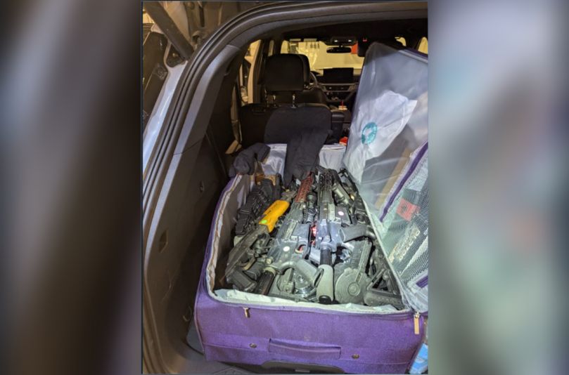 A suitcase filled with firearms in the back of an SUV is seen in a handout photo from U.S. authorities. Three suspects have been charged with attempting to smuggle firearms into Canada. (U.S. Department of Justice)