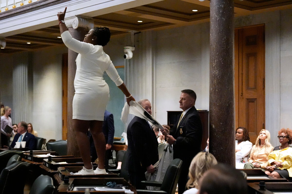 A member of the Senate Sargeant-at-Arms (R) pulls a banner out of the hands of state Sen. Charlane Oliver, a Democrat representing Nashville, as she protests the redrawing of U.S. congressional voting maps during a special session of the state legislature in Nashville on May 7, 2026. (George Walker IV/AP Photo)
