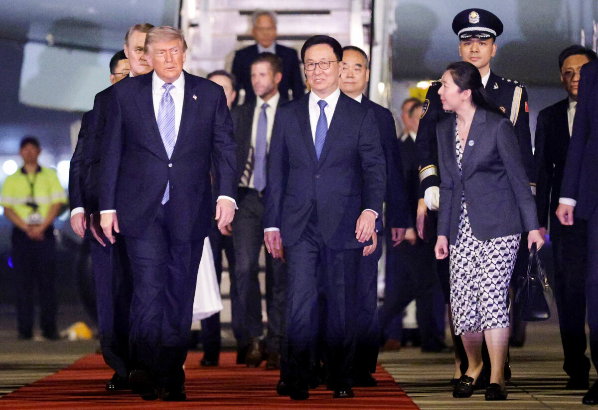 Chinese Vice President Han Zheng (C) escorts U.S. President Donald Trump (L) as he arrives at Beijing Capital International Airport on May 13, 2026 in Beijing. (Alex Wong/Getty Images)