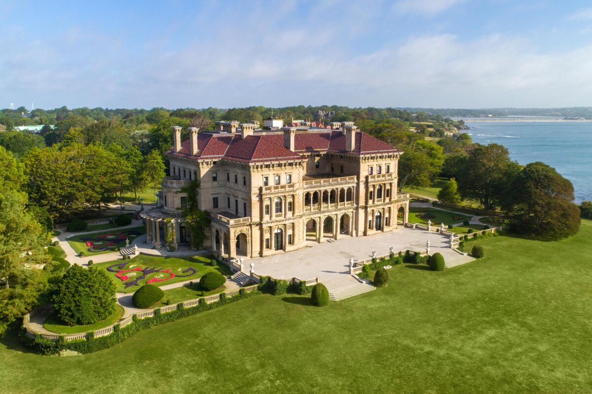 The largest and most opulent of Newport's Gilded Age mansions, The Breakers sits on 13 acres overlooking the Atlantic Ocean. A 12-foot limestone and iron fence borders the property on three sides, flanked by dense plantings of rhododendrons and ornamental dogwoods. The grounds are home to several rare tree varieties, including weeping beeches and Blue Atlas cedar. (The Preservation Society of Newport County)