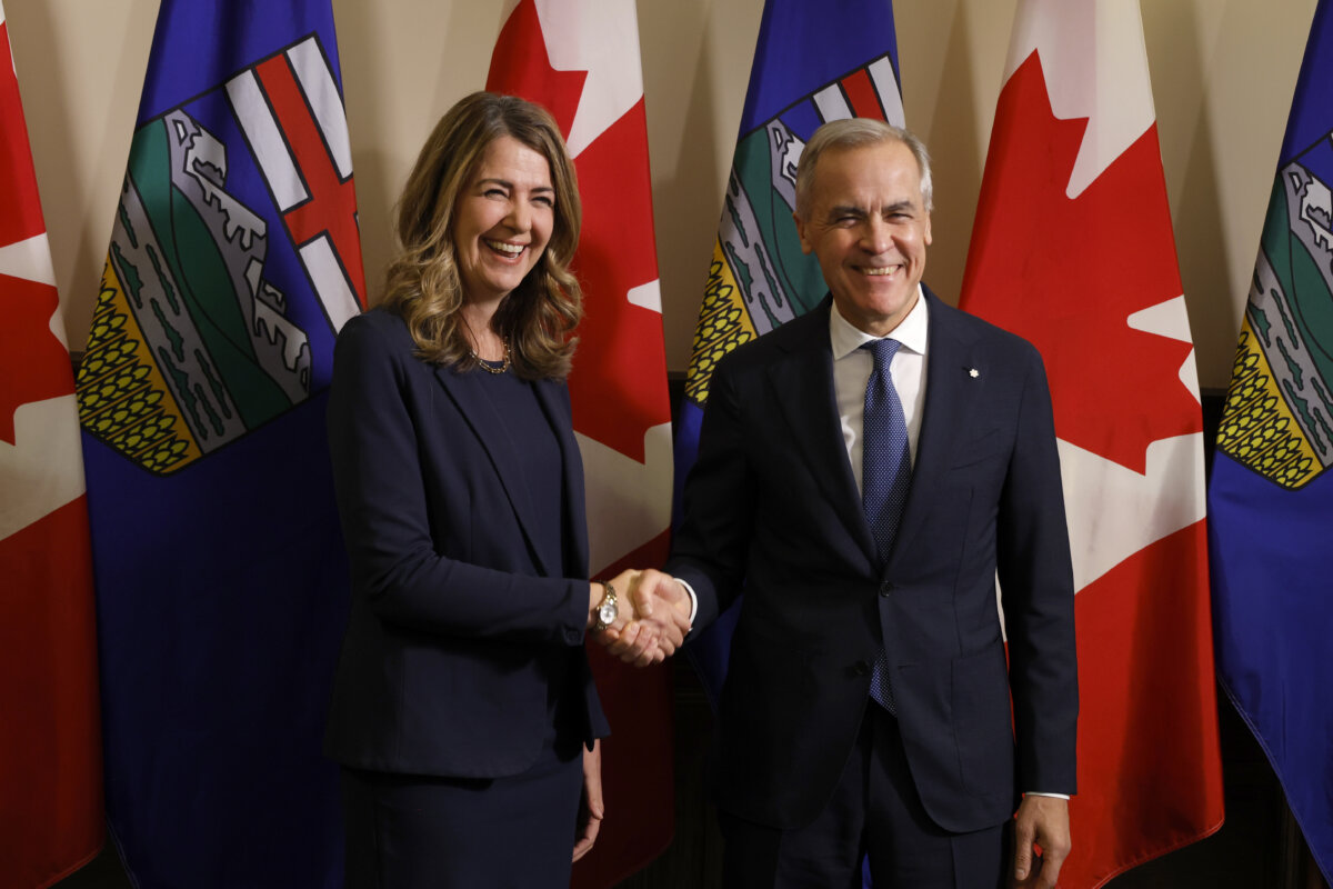 Prime Minister Mark Carney shakes hands with Alberta Premier Danielle Smith in Calgary, May 15, 2026. (The Canadian Press/Jeff McIntosh)