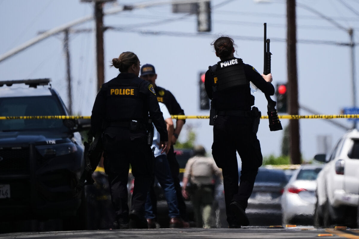 People carry weapons at the scene of a shooting outside the Islamic Center of San Diego in San Diego on May 18, 2026. (Gregory Bull/AP Photo)