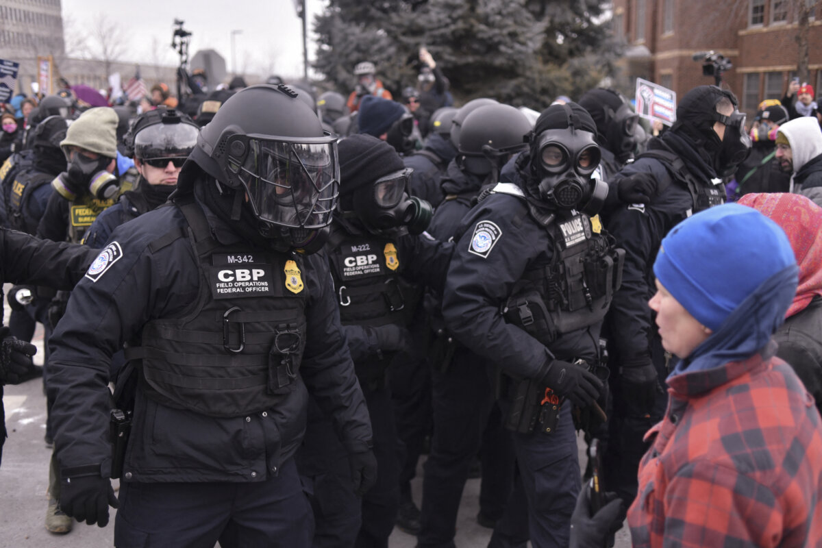 Federal law enforcement agents confront anti-ICE protesters during a demonstration outside the Bishop Whipple Federal Building in Minneapolis, Minnesota, on January 15, 2026. Hundreds more federal agents were heading to Minneapolis, the US homeland security chief said on January 11, brushing aside demands by the Midwestern city's Democratic leaders to leave after an immigration officer fatally shot a woman protester. In multiple TV interviews, US Homeland Secretary Kristi Noem defended the actions of the officer who shot and killed 37-year-old Renee Nicole Good, whose death has sparked renewed protests nationwide against President Donald Trump's immigration crackdown. (Photo by Octavio JONES / AFP via Getty Images)