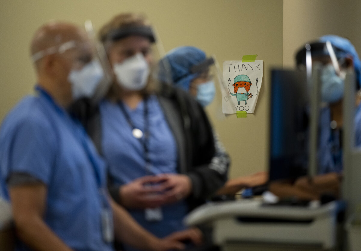 Head intensivist Sanjay Manocha (L) makes his rounds at the Humber River Hospital in Toronto on Jan. 25, 2022. (The Canadian Press/Nathan Denette)