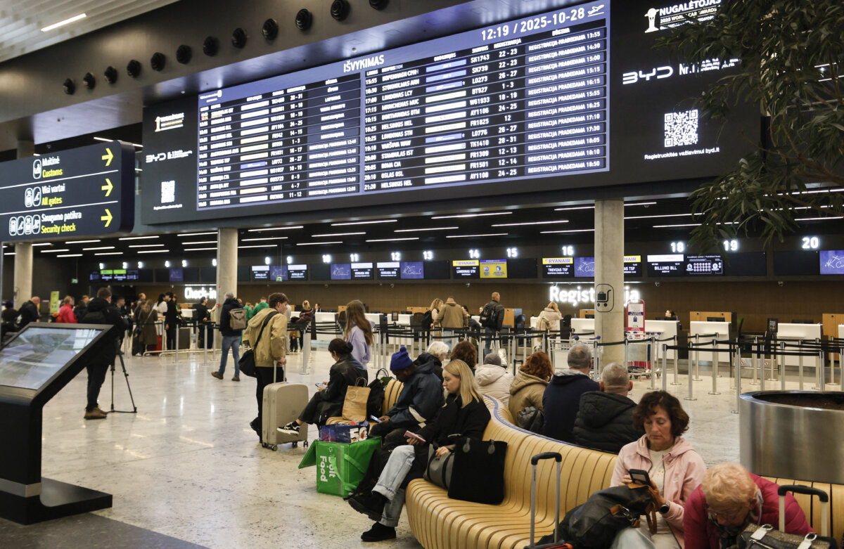 Flight passengers are pictured at a hall of the airport in Vilnius, Lithuania, on October 28, 2025. (Petras Malukas / AFP via Getty Images)