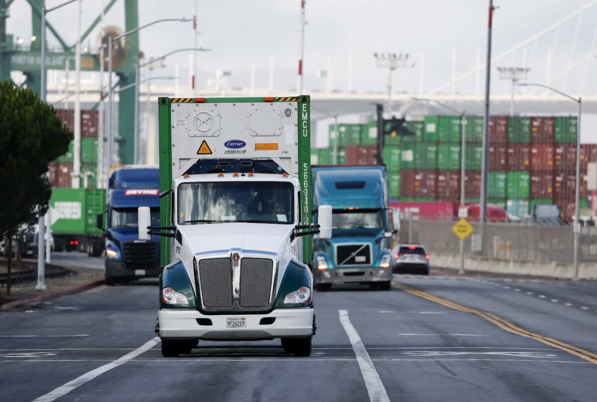 Trucks drive through the Port of Oakland in Oakland, California on November 14, 2025. California is preparing to revoke 17,000 commercial driver's licenses that were issued to immigrants whose license expiration dates exceeded their legal U.S. stay. (Justin Sullivan/Getty Images)