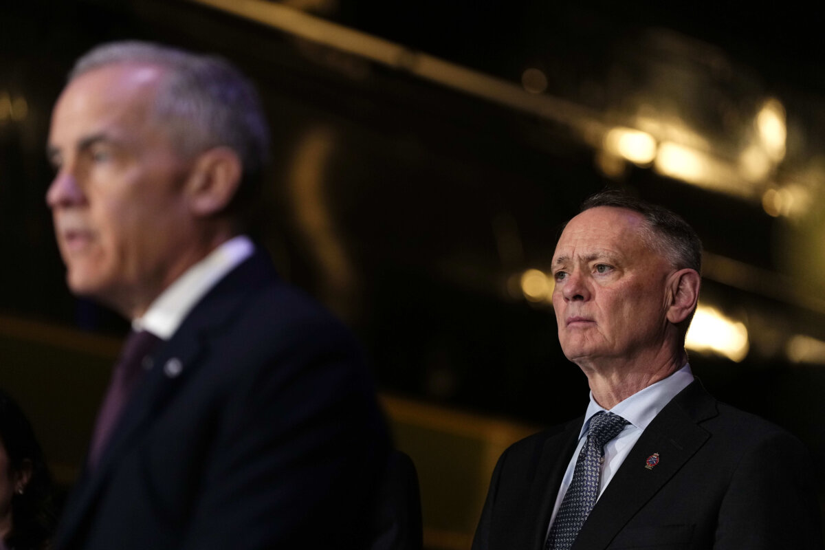 File photo—Defence Minister David McGuinty (R), listens as Prime Minister Mark Carney speaks in Ottawa, on April 27, 2026. (The Canadian Press/Justin Tang)