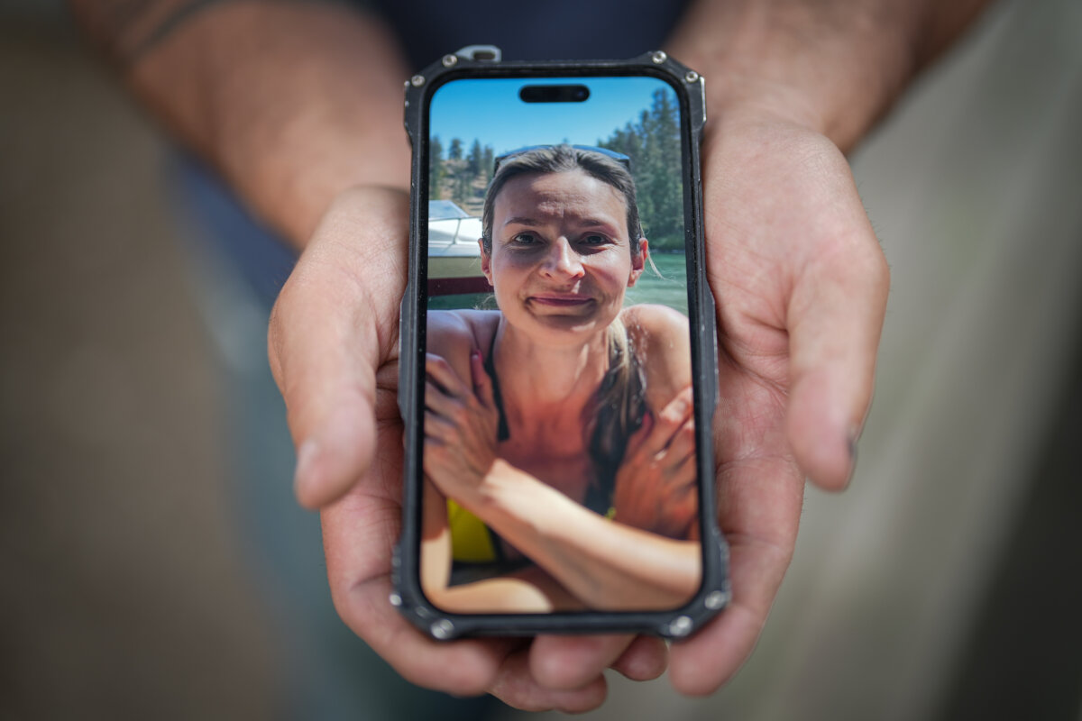 Jason Gaudreault, whose partner Tatjana Stefanski was found dead on April 14, 2024, after disappearing a day earlier, shows a photograph of her on his phone, in Lumby, B.C., on May 13, 2024. (The Canadian Press/Darryl Dyck)