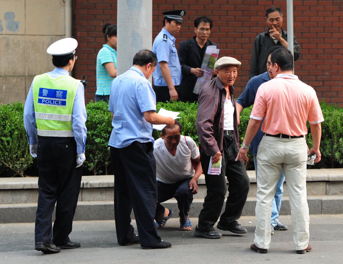 Elderly petitioners protesting about medical and land grab issues are detained by police outside the Chaoyang Hospital where blind activist Chen Guangcheng is staying in Beijing on May 10, 2012. (Mark Ralston/AFP/GettyImages)
