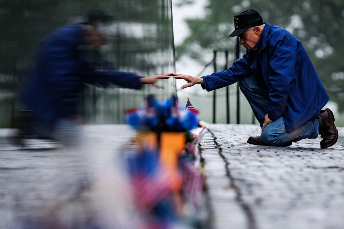 David Loesch, a veteran of the U.S. Army's 101st Airborne and the Vietnam War, reaches out to touch a fallen comrade's name etched into the black granite at the Vietnam Veterans Memorial on Memorial Day on May 25, 2026 in Washington, D.C. (Samuel Corum/Getty Images)