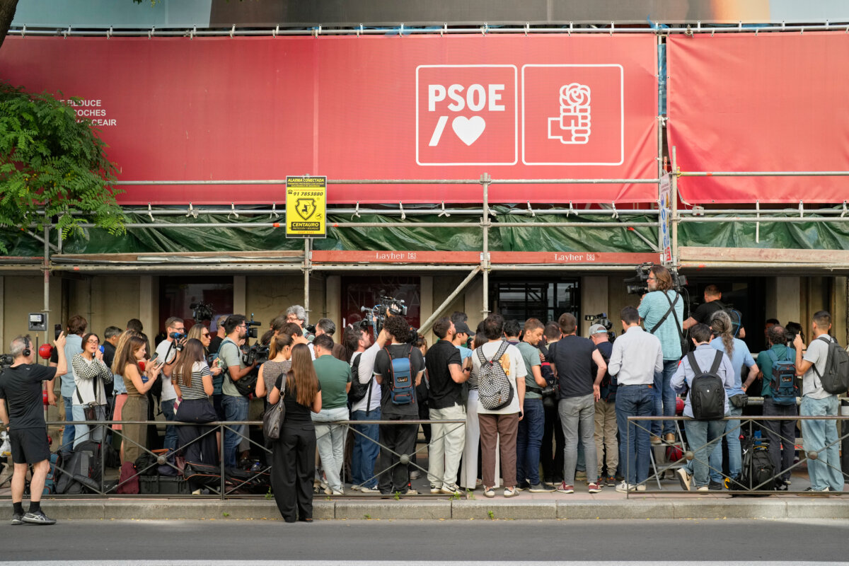 Journalists gather outside the headquarters of Spain's ruling Socialist Party as police search the building, in Madrid on May 27, 2026. (Bernat Armangue/AP)