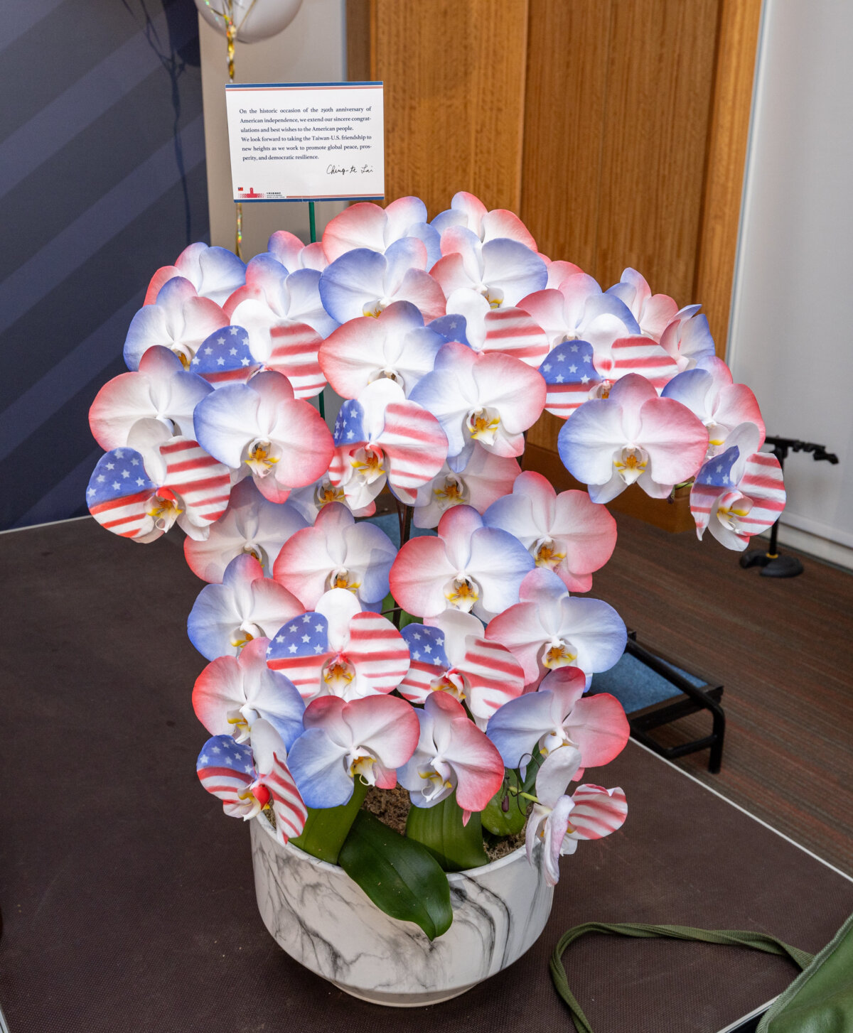 On May 27, President Lai Ching-te attended the "Celebrating America's 250th Anniversary" event hosted by AIT. He presented a special orchid grown by farmers in Tainan. The flower’s petals are arranged in the pattern of the American flag. Wang Yu Ching / Office of the Taiwan President
