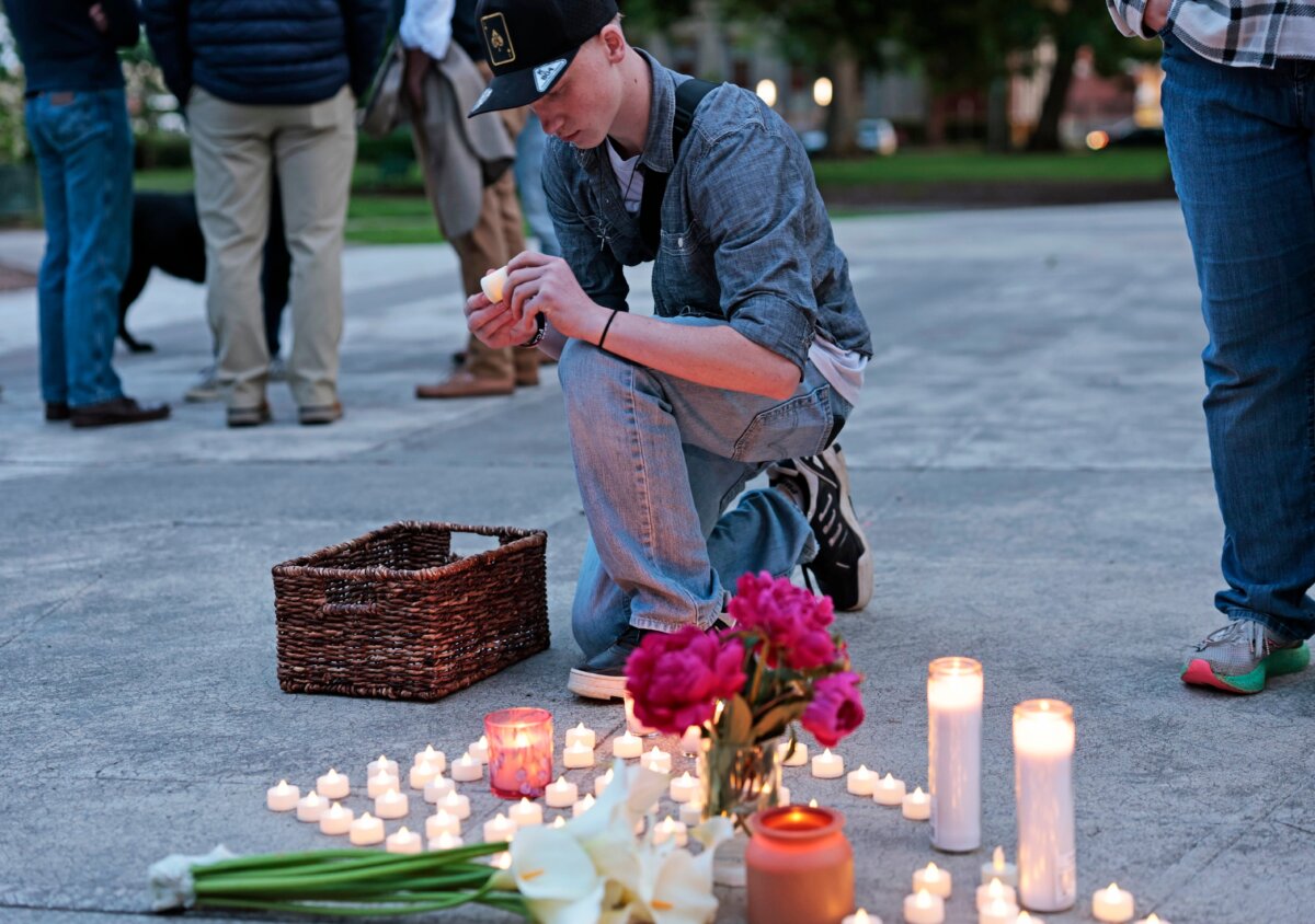 Kaeden Beck, 16, lays down candles during an evening prayer and vigil, in support for the victims and their families impacted by Nippon Dynawave Packaging Co. tank implosion, at R.A. Long Park in Longview, Wash., on May 26, 2026. (Karen Ducey/The Seattle Times via AP)