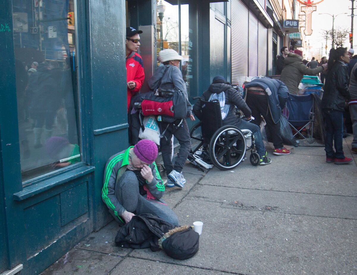 People gather outside a supervised consumption site in the Downtown Eastside of Vancouver on Feb. 21, 2017. (The Canadian Press/Darryl Dyck)