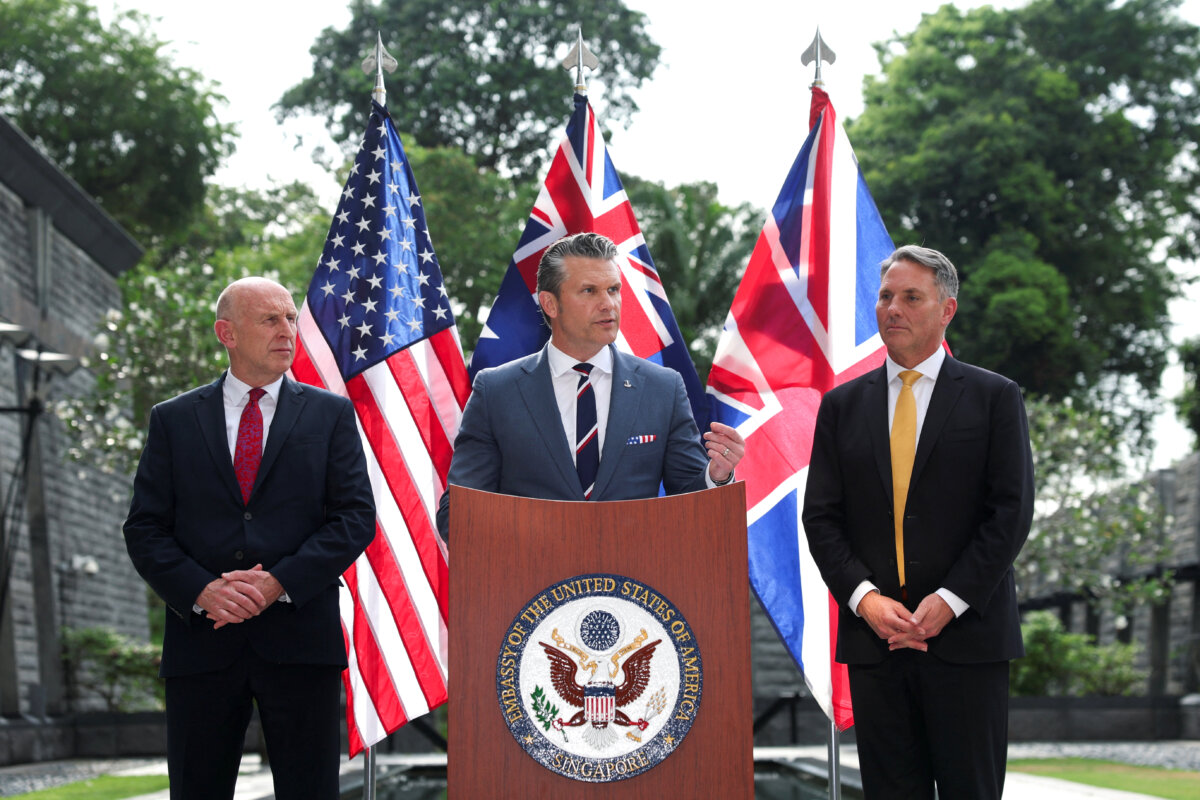 Australian Defense Minister Richard Marles and British Defense Secretary John Healey look on as U.S. Secretary of War Pete Hegseth speaks during an AUKUS defense ministers' press huddle at the U.S. Embassy in Singapore, on May 30, 2026. (Edgar Su/Reuters)