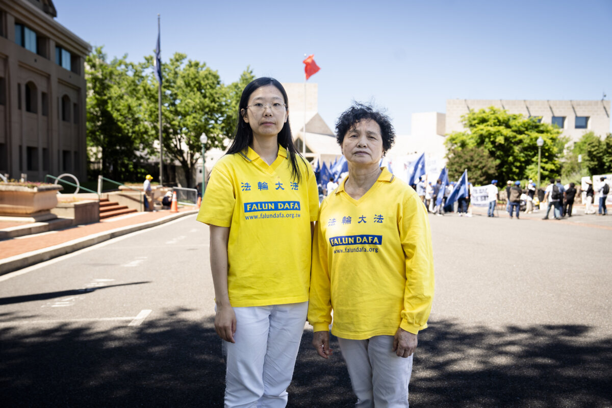 Falun Gong practitioners Alisa Zhou (L) and Tong Shuzhen stand in front of the Chinese Embassy in Washington on May 30, 2026. Zhou's mother Wang Youmei and Tong's sister Tong Shuying have been detained since April in Wuhan, China, because of their faith. (Madalina Kilroy/The Epoch Times)