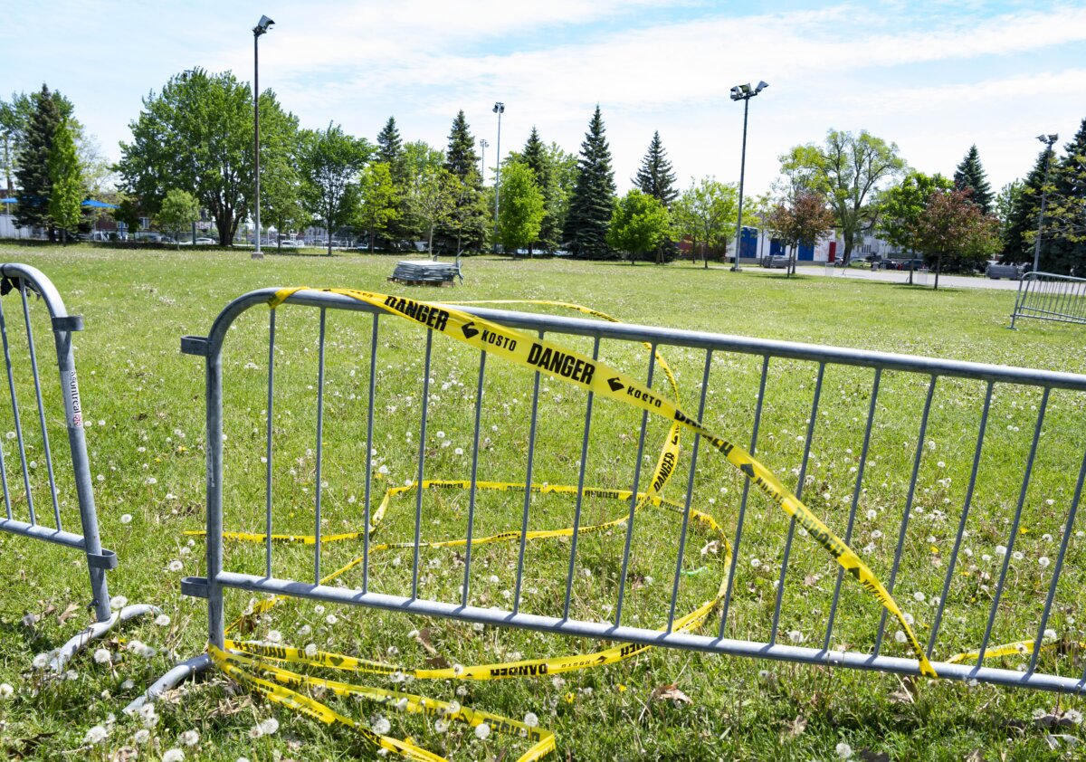 Warning tape is wrapped around barriers in Parc Ouellette in the Montreal borough of LaSalle on June 2, 2026. A toddler died of her injuries after a bouncy castle was swept up by strong winds on May 31, 2026. (The Canadian Press/Christinne) Muschi
