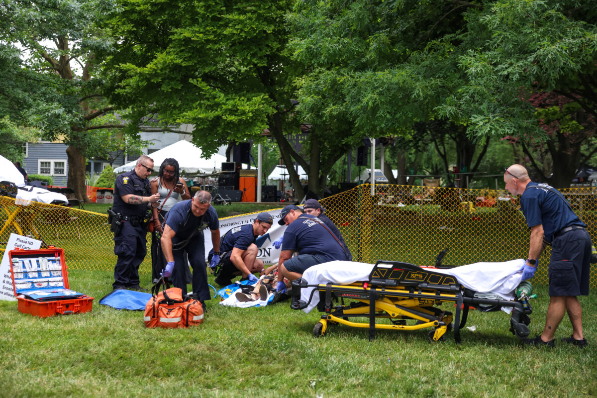First responders help a woman who was injured in the shooting that left 12 people injured at the Old West End Festival at the Agnes Reynolds Jackson Arboretum in Toledo, Ohio, on June 6, 2026. (Rebecca Benson/The Blade via AP)